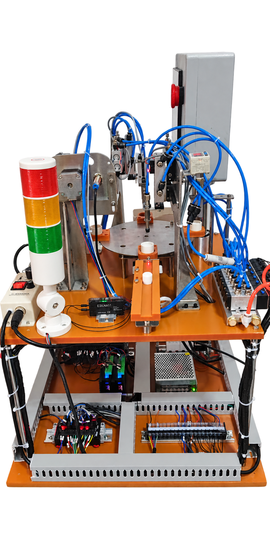 Rear view of rotary assembly trainer showing pneumatic valves, sensors and electrical layout; PLC configuration varies